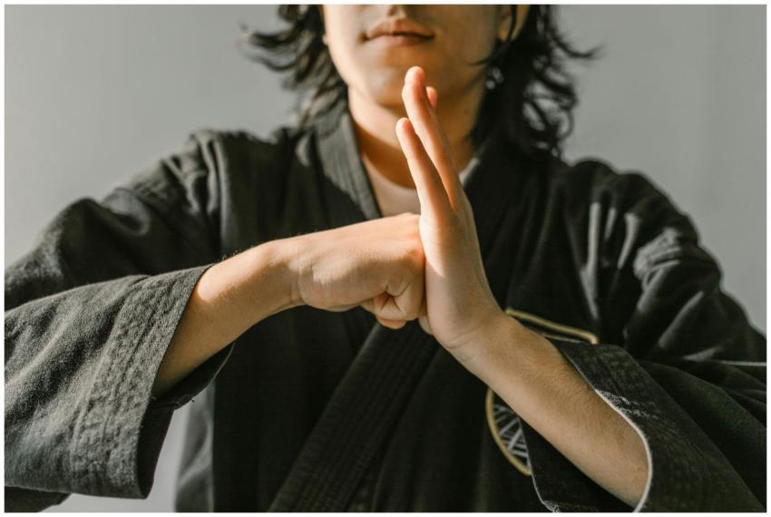 Close-up of a martial artist in black gi showing a