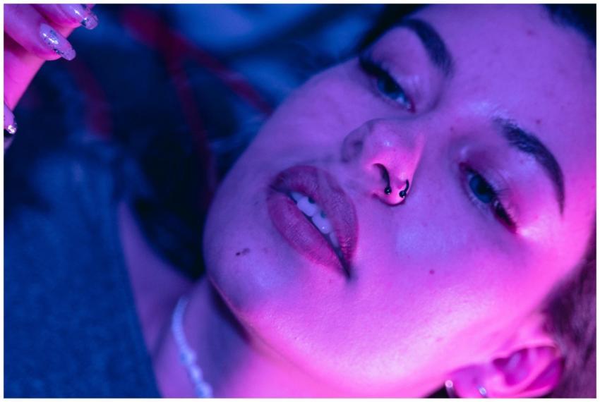 A close-up portrait of a woman illuminated by vibr