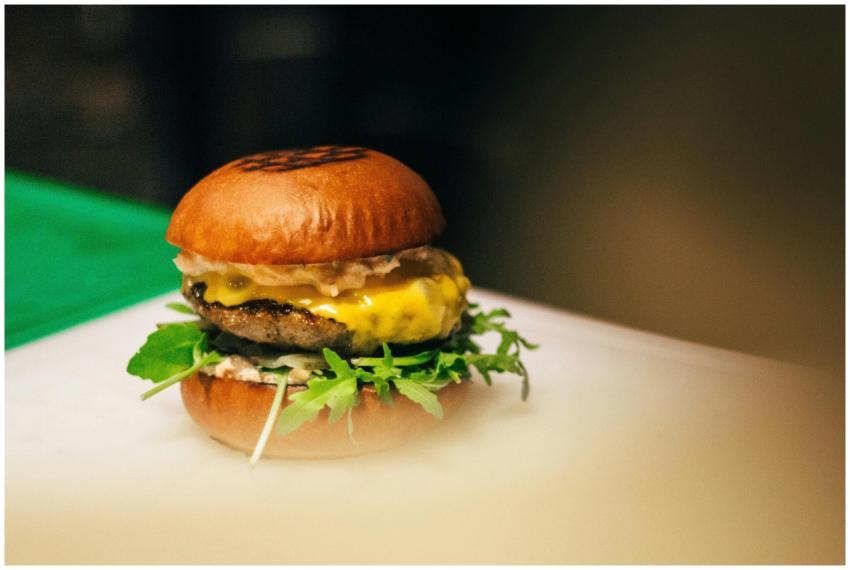 Close-up of a gourmet cheeseburger with fresh vege