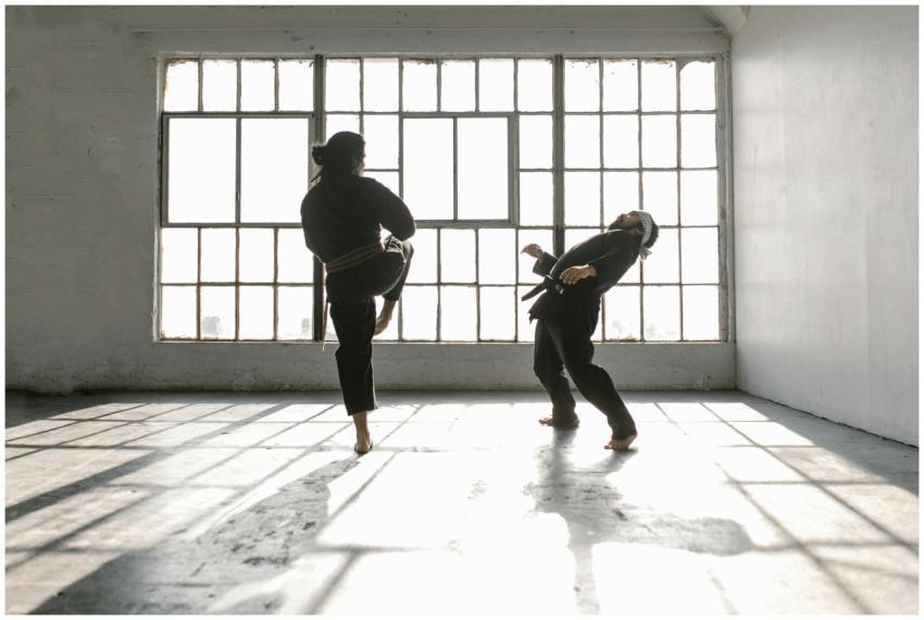 Two martial artists practice self-defense techniqu