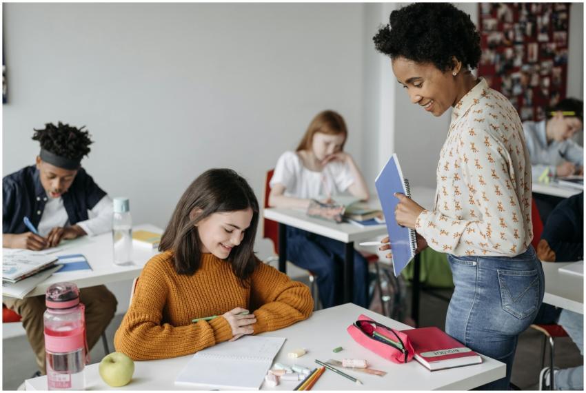 Teacher assisting students in a classroom setting,