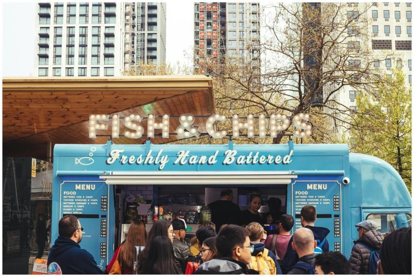 Crowd enjoying fish and chips at a lively food tru