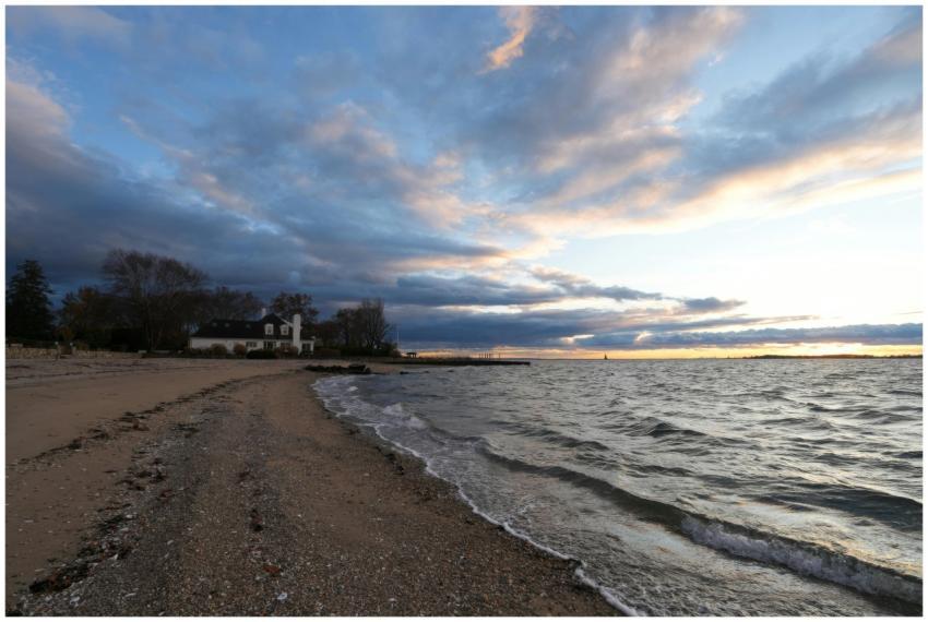 Serene beach at sunset with lush clouds and gentle