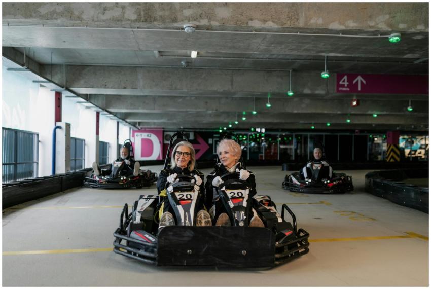 Elderly friends having fun racing go-karts indoors