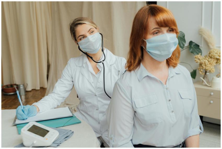 A healthcare worker in a mask conducts a medical e