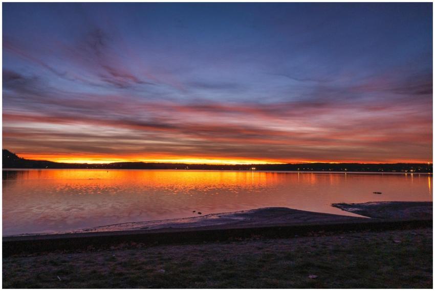Vibrant sunset over a serene lake, reflecting vivi