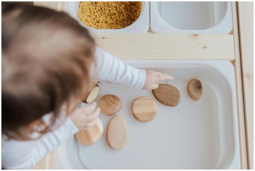 A toddler playing with wooden stones in a Montesso