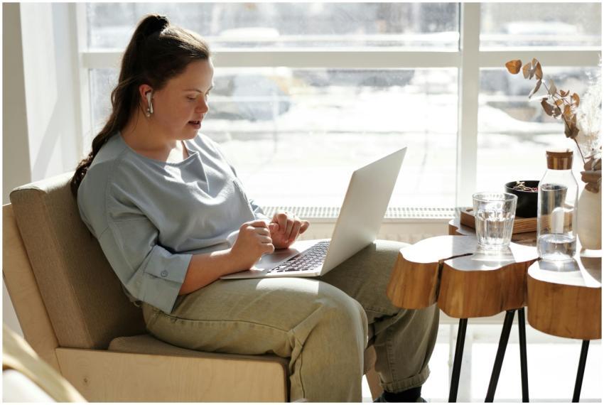 Young woman with Down syndrome using a laptop at h