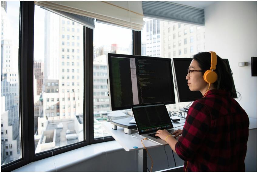 A businesswoman coding at a standing desk with cit