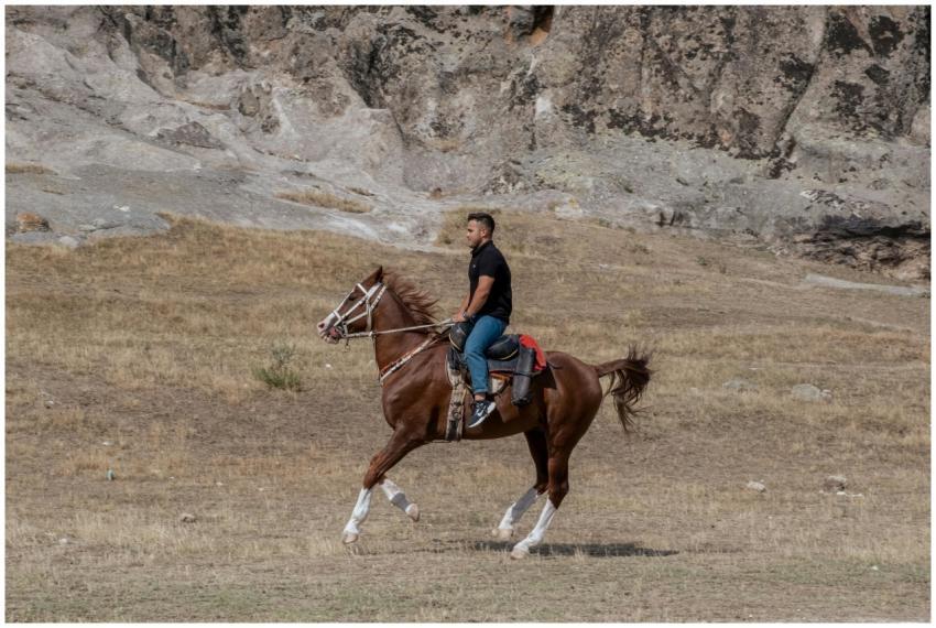 Man riding a horse through rocky terrain in Afyonk