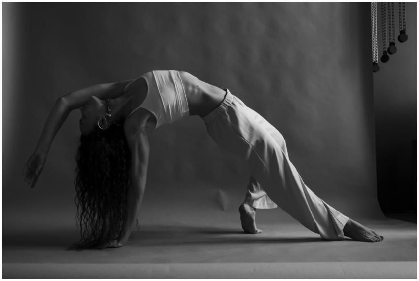 A woman in a graceful yoga pose in a monochrome st