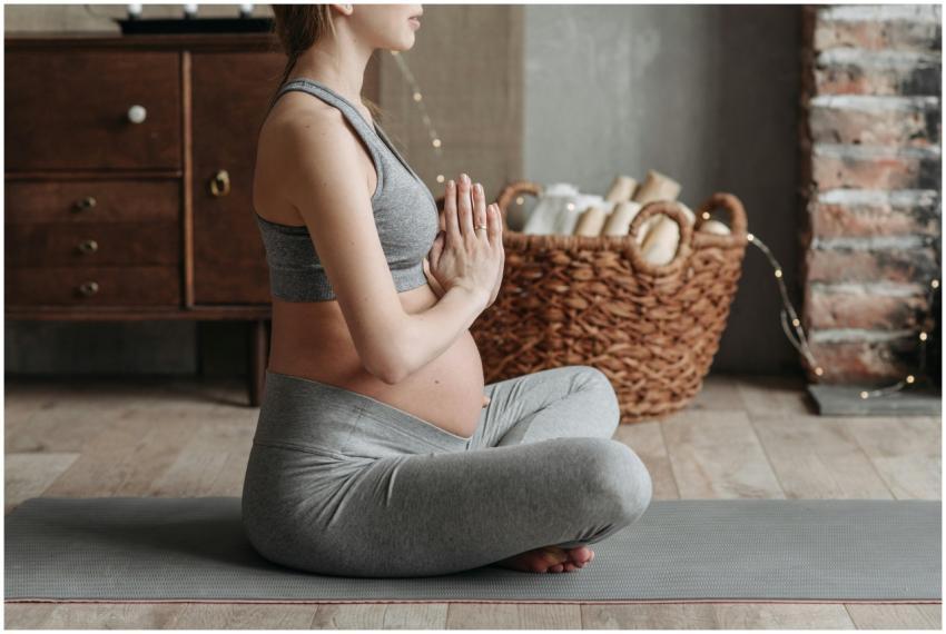 Side view of a pregnant woman practicing meditatio