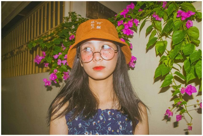 Young woman in a bucket hat and eyeglasses surroun