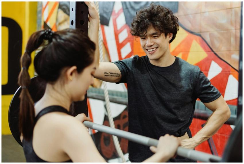 Smiling personal trainer coaching a woman lifting