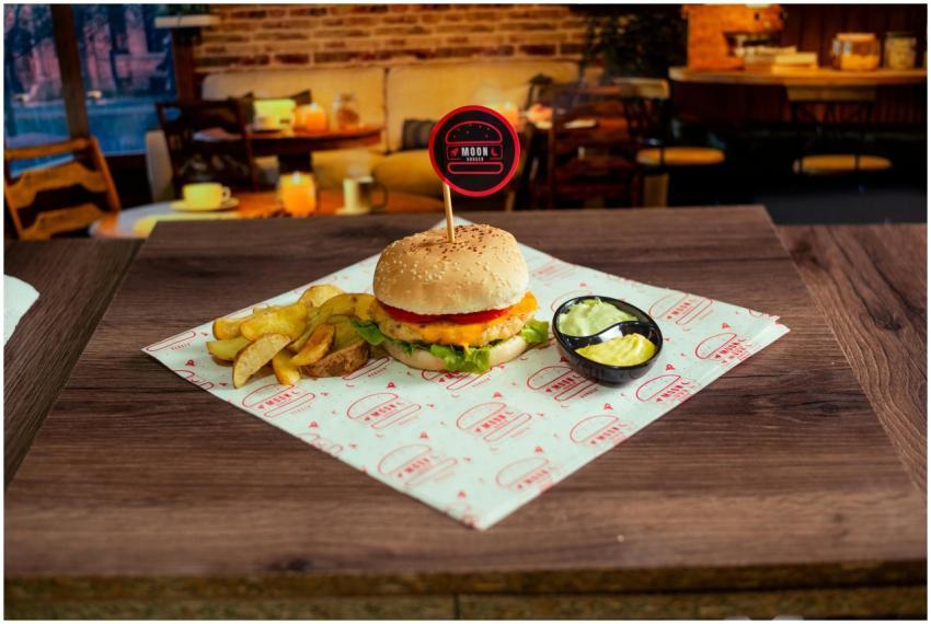 Appetizing cheeseburger with fries and dips on a w