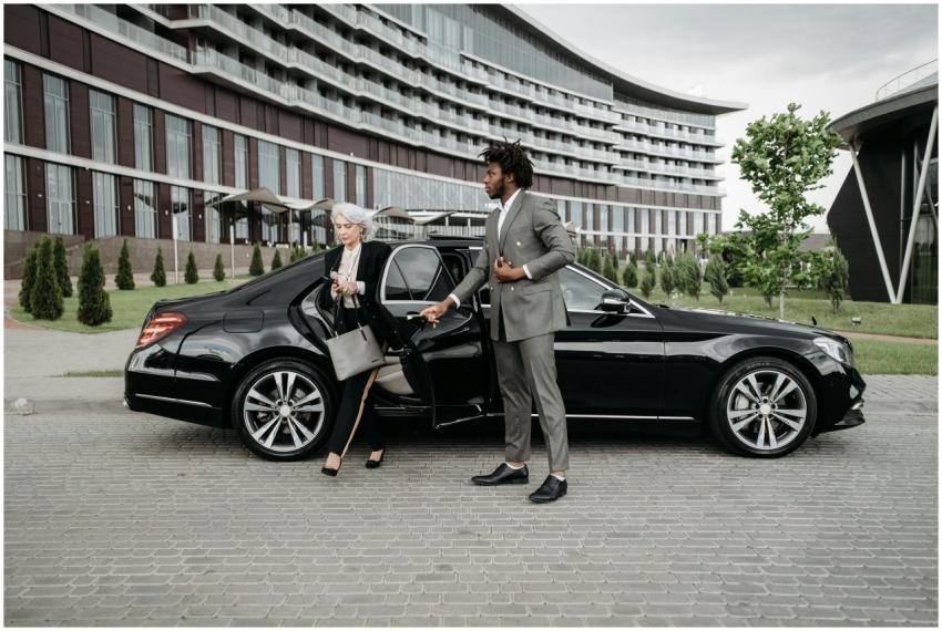 A professional chauffeur assists a businesswoman e