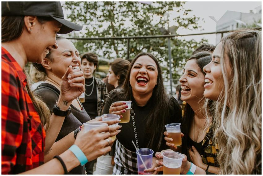Group of young women laughing and enjoying drinks