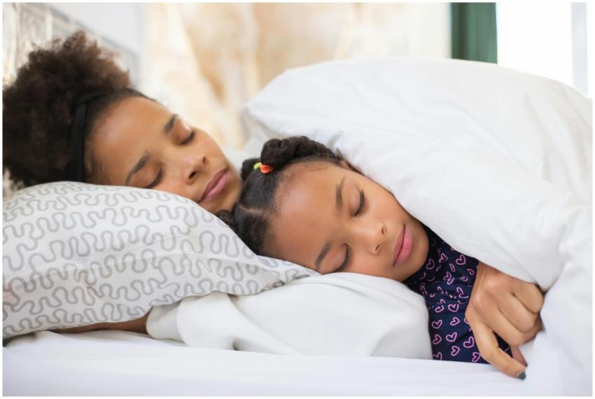 Tender moment of mother and daughter sleeping clos