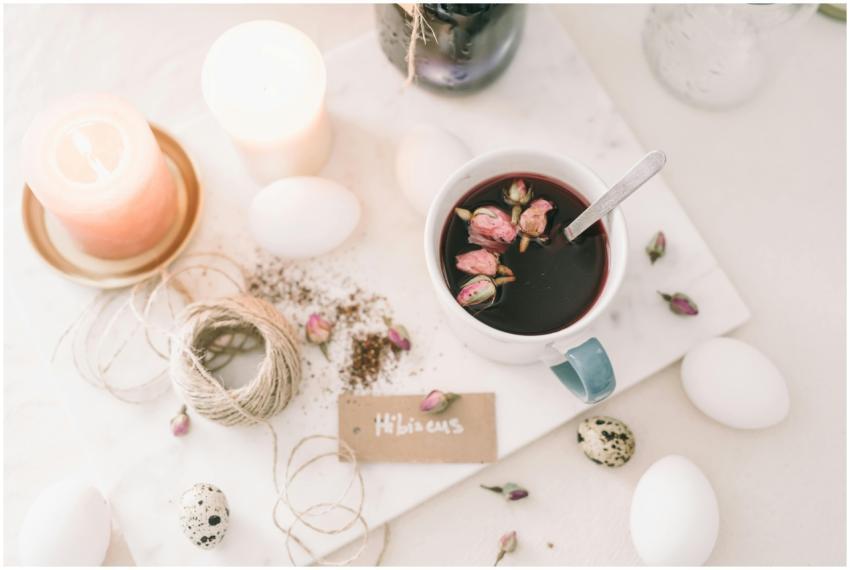 A serene flatlay featuring hibiscus tea, candles,