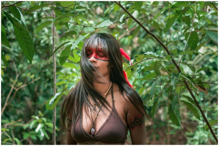 Portrait of a woman with vibrant face paint surrou