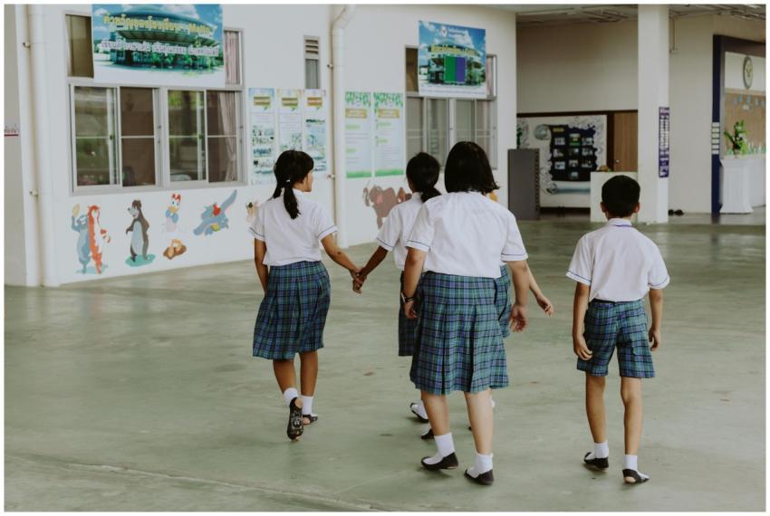 Children in school uniforms walking together indoo
