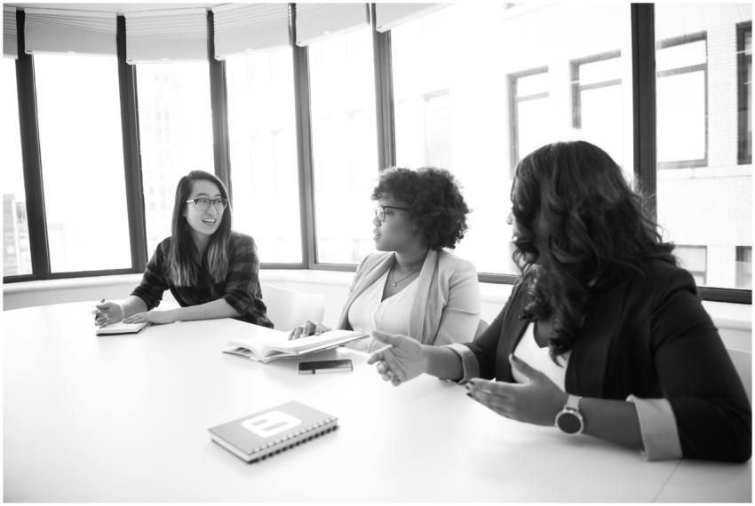 Three women engaged in a business meeting around a