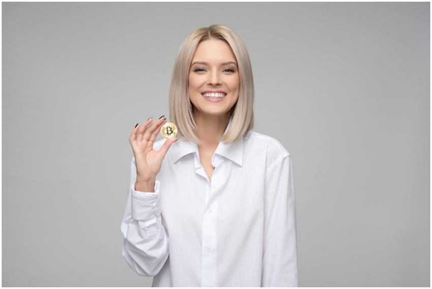 A cheerful woman displaying a bitcoin, embodying d