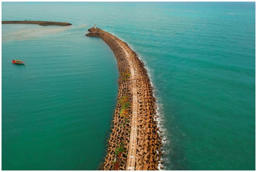 Drone shot showcasing a scenic coastal jetty exten