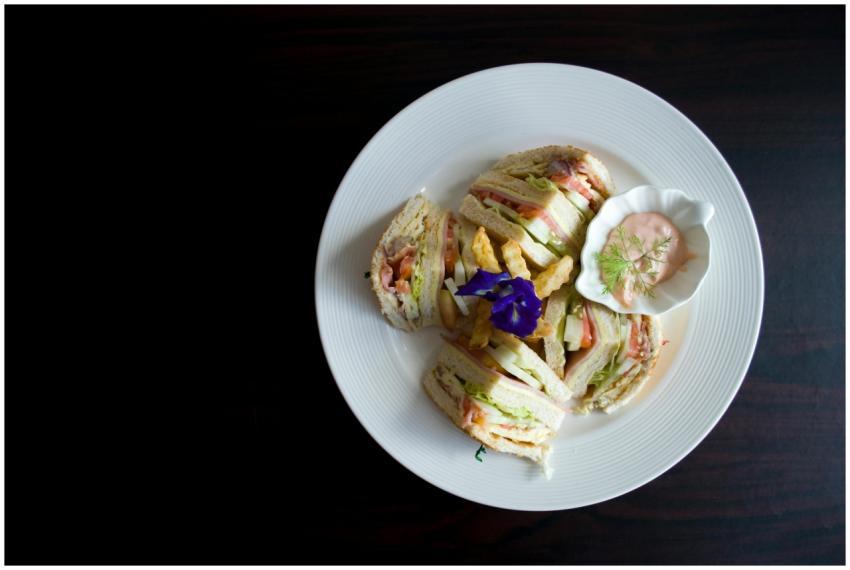 Delicious clubhouse sandwich with sauce and floral