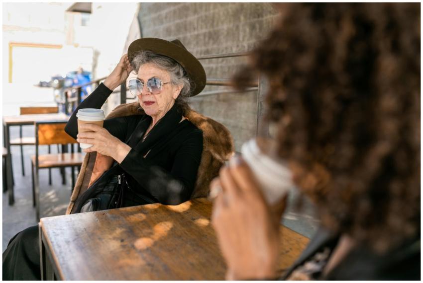 Stylish senior woman sipping coffee outside in a r