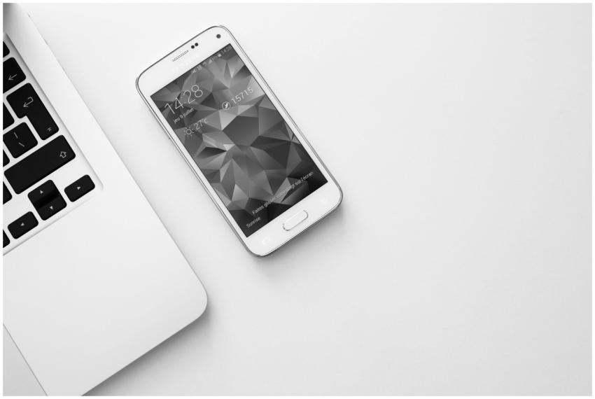 A minimalist office desk with a laptop and smartph