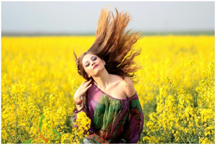 Vibrant portrait of a woman in a yellow flower fie
