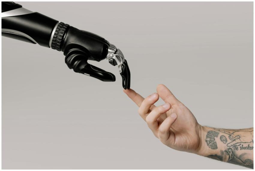 A human hand with tattoos reaching out to a roboti