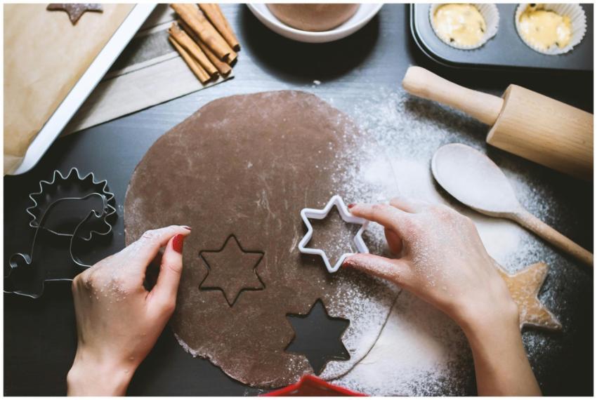 Hands cutting star-shaped cookies from chocolate d