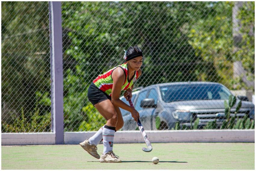 Female field hockey player in action on a sunny ou