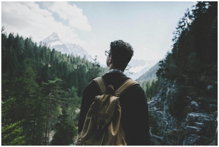 Back view of a man with a backpack hiking through