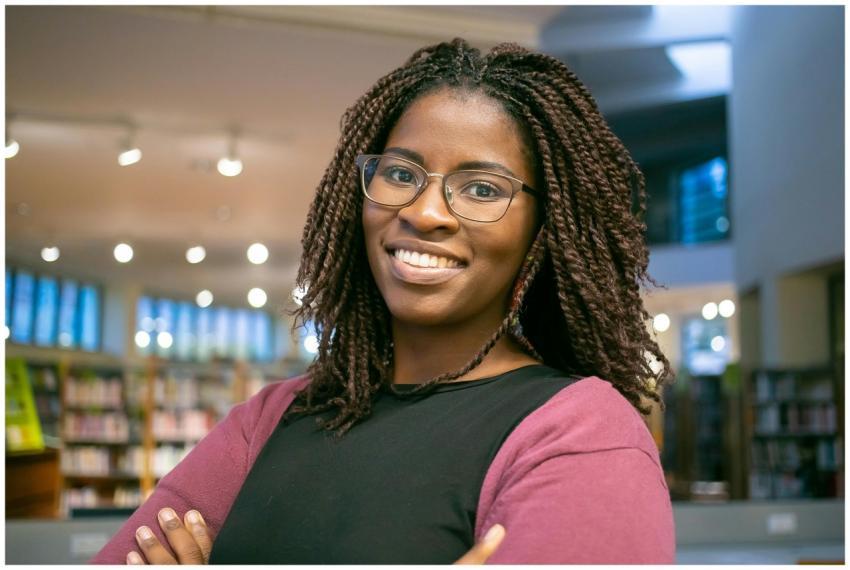 Smiling woman with eyeglasses in a library, convey