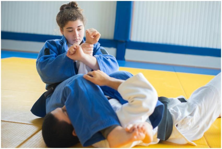 Two judokas practicing arm lock technique on dojo