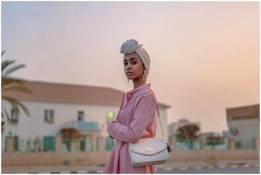 Stylish woman in pink dress with turban, posing ou