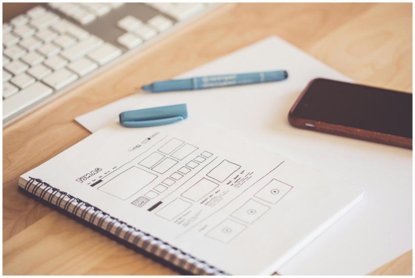 A neat workspace featuring a sketchpad with wirefr