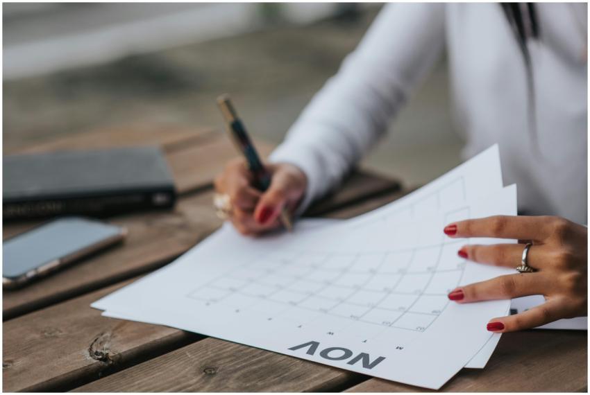 A woman planning with a calendar outdoors, jotting