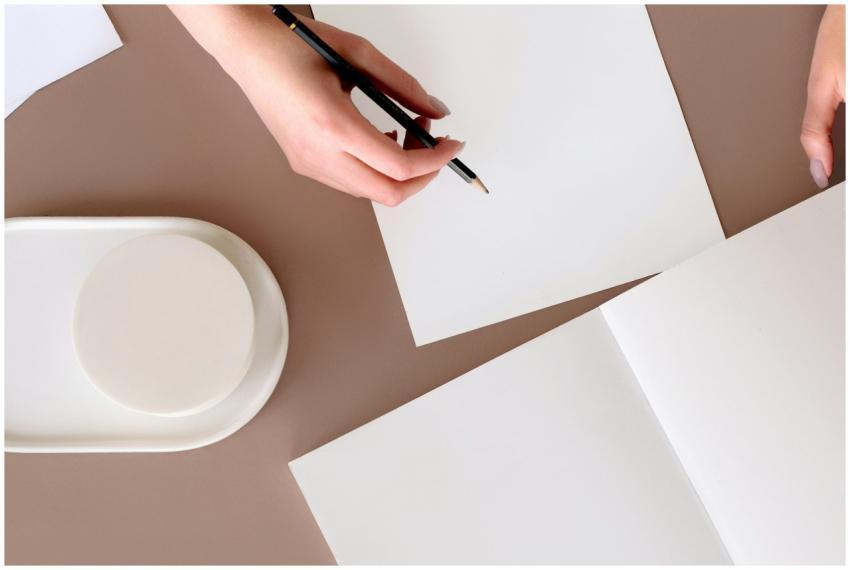 Hands poised for creativity on an empty notepad, r