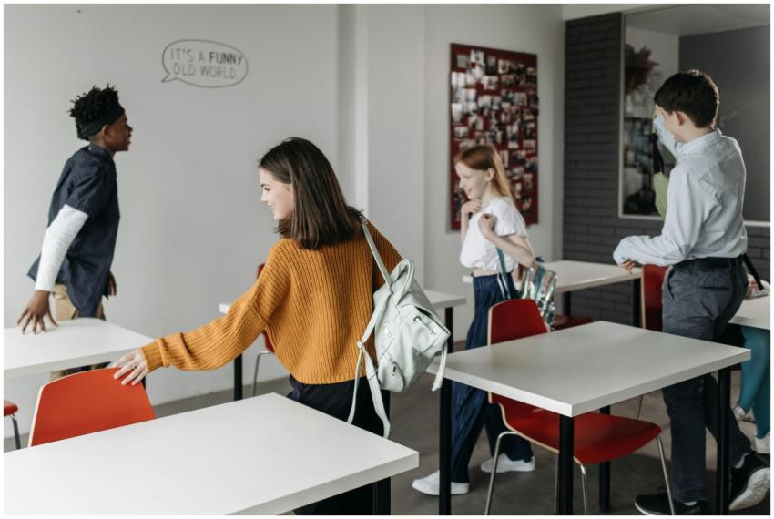 A group of cheerful students leaving a classroom,