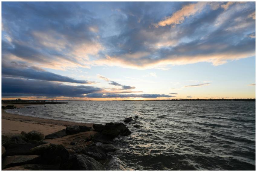 A serene sunset over a rocky beach with picturesqu