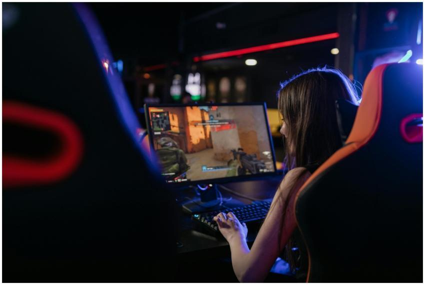 A woman is deeply engaged in playing computer game