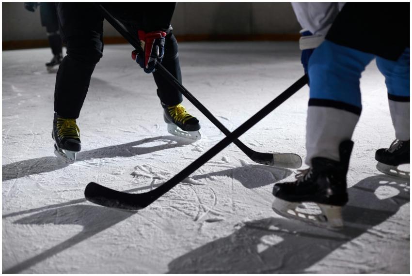 Close-up of hockey players battling for puck durin