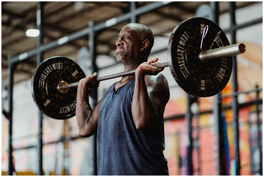 A focused man lifting a heavy barbell during a wor