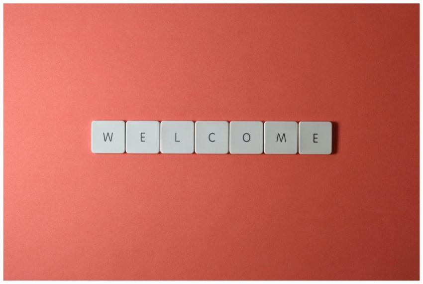 Flat lay of white tiles spelling 'WELCOME' on a re