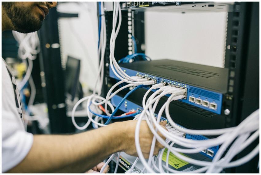 An IT professional configuring network cables in a