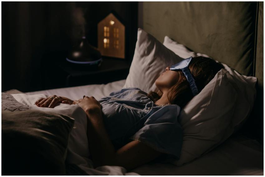 A woman peacefully sleeping with an eye mask in a